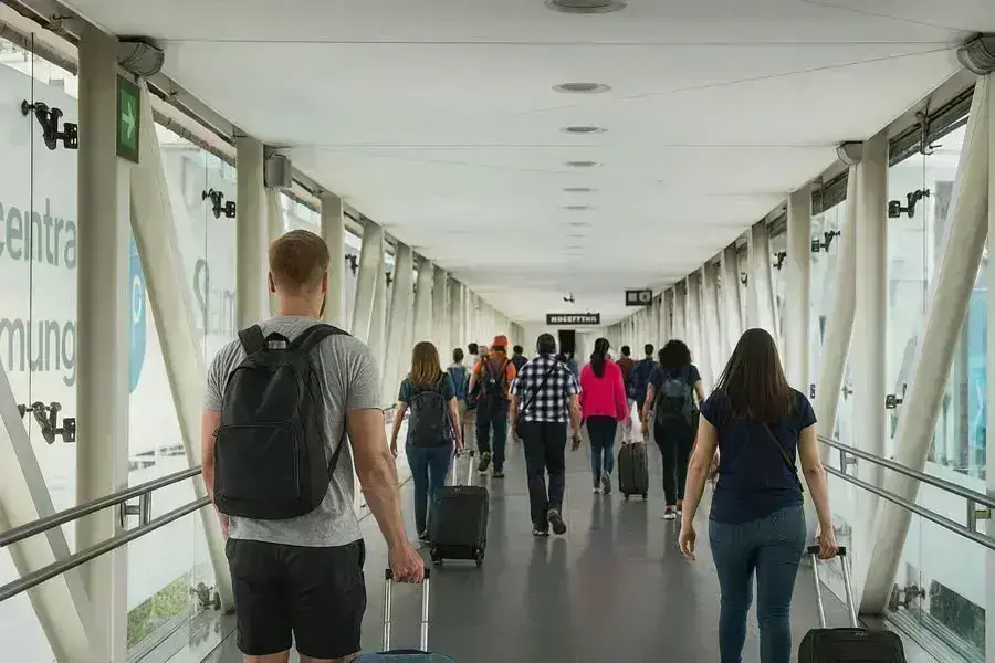 Pasajeros caminando con maletas por el Puente de Pilotos hacia el and&eacute;n del Aerotr&eacute;n que conecta las terminales 1 y 2 del Aeropuerto Internacional de la Ciudad de M&eacute;xico