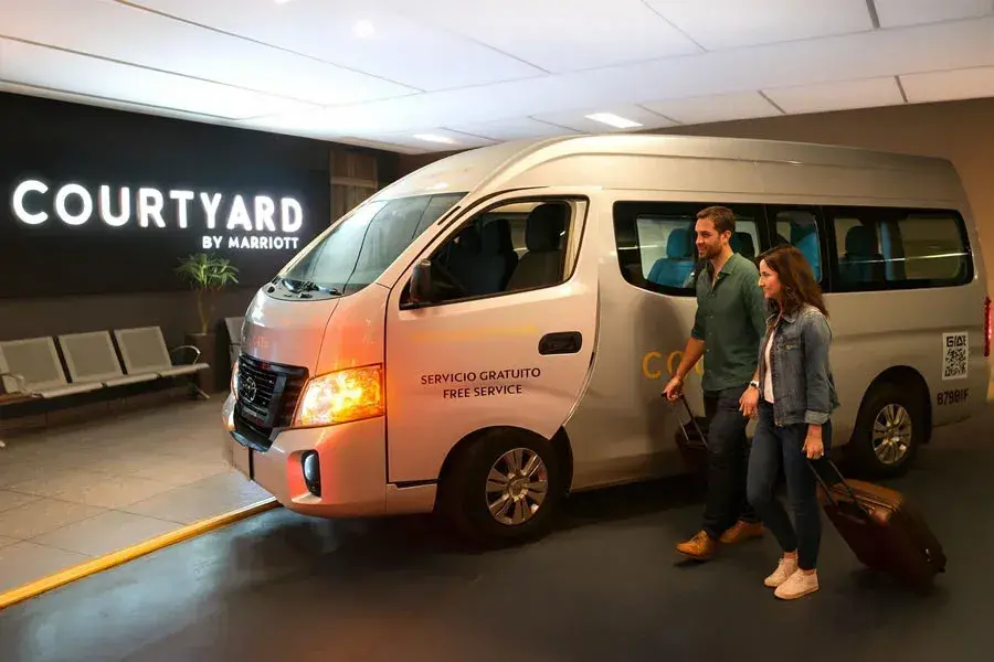 Pasajeros con maletas saliendo de una van deCourtyard Marriot Mexico City Airport